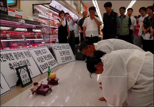 제해식 전농 부경연맹 의장과 박점옥 경남여성농민회장이 이마트 창원점 수입육 판매장 앞에서 고사를 지내고 있다. 